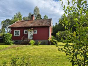 StälldalenにあるFerienhäuschen in Ställdalenの庭白い扉付き赤い家