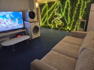 a living room with a couch and a flat screen tv at Moomoo House in Busan