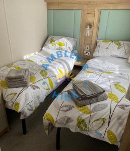 two beds sitting next to each other in a room at Amblers Hide, Brigham, Cockermouth, Cumbria in Cockermouth