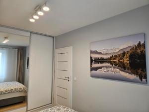 a bedroom with a painting on the wall at Apartament Azul in Cieszyn