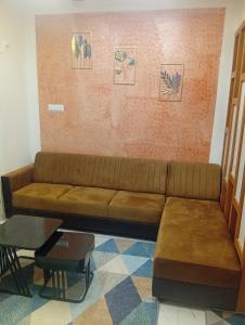 a brown couch sitting in a living room at Gurunandanam in Guruvāyūr