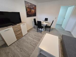 a living room with a flat screen tv and a table at FERIENWOHNUNG 75m2 APARTMENT in ZITTAUER STADTZENTRUM INNENSTADT INNENRING TOP LAGE - WOHNEN AUF ZEIT IN ZITTAU - 3 RAUM WOHNUNG in Zittau