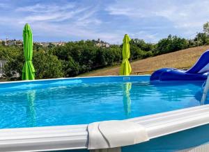 a swimming pool with two lawn chairs and two umbrellas at Casa Vacanze Il Vallo - Appartamenti con Piscine Indipendenti in Guardiagrele