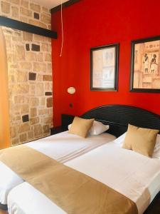 two beds in a room with a red wall at Hotel Dunas Boavista in Sal Rei +38 photos