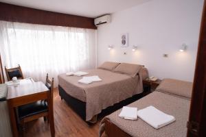 a hotel room with two beds and a table and chairs at Hotel Centenario in Atlántida +58 photos