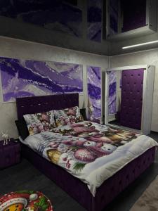 ein Schlafzimmer mit einem großen Bett mit einem lila Kopfteil in der Unterkunft Casa Daiana in Aninoasa