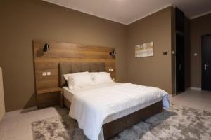 a bedroom with a large bed with a wooden headboard at Μεσιέ Νικολά 700 in Mesenikólas