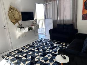 een woonkamer met een zwarte bank en een geruite vloer bij Vale Premium Solaris apartamento in Petrolina +11 foto's