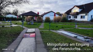 un giardino con una casa e un cortile con case di Ruhiges Elbhäuschen nahe Hamburg a Hollern-Twielenfleth