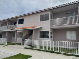 een appartementencomplex met een wit hek ervoor bij Vale Premium Solaris apartamento in Petrolina