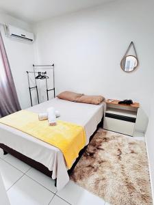 een slaapkamer met een bed, een bureau en een tapijt bij Vale Premium Solaris apartamento in Petrolina