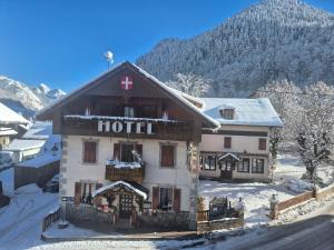a hotel in the snow in front of a mountain at Les Touristes in Abondance