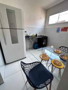 een keuken met een koelkast en een tafel en stoelen bij Vale Premium Solaris apartamento in Petrolina