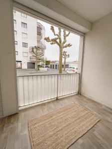 an empty room with a large window and a rug at Vacances en bord de mer in Royan