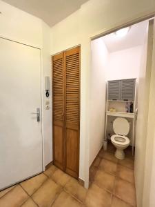 a bathroom with a toilet and a wooden door at Vacances en bord de mer in Royan