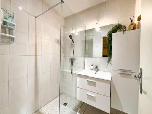 a white bathroom with a sink and a shower at Vacances en bord de mer in Royan +1 photo