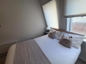 a bedroom with a bed with two pillows and a window at Tyneside 2 beds in Gateshead