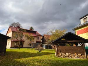 a house with a pile of fire wood in a yard at Penzion U Lípy in Velké Karlovice