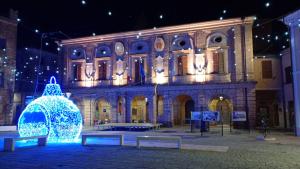 a building with a christmas tree in front of it at Il Buchetto - casa vacanza Potenza Picena in Potenza Picena