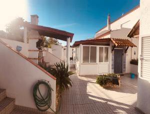 een wit huis met een poort en een binnenplaats bij Shell's Apartment in Praia do Carvoeiro