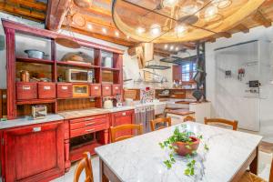 a large kitchen with wooden cabinets and a table at Pura Apartment Hill View Stay near Peccioli & Lajatico in Palaia