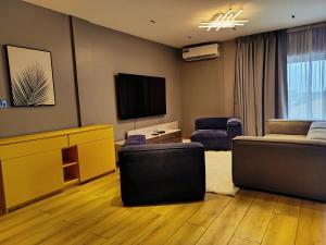 een woonkamer met banken en een flatscreen-tv bij 1949 Luxury Apartment in Ashalebotwe