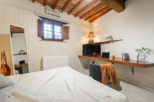 a bedroom with a bed and a desk and a window at Pura Apartment Hill View Stay near Peccioli & Lajatico in Palaia