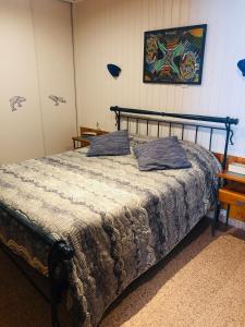 een slaapkamer met een bed en een schilderij aan de muur bij Shell's Apartment in Praia do Carvoeiro