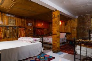 a bedroom with two beds in a room with wooden walls at Dar Merzouga Meknes in Meknès