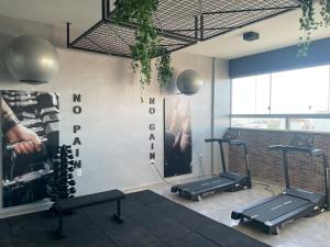 a gym with three treadmills and a poster on the wall at Refúgio central in Barbacena