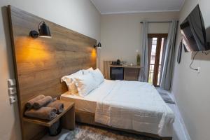 a bedroom with a white bed with a wooden headboard at Mesie Nicola 700 
