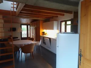 a kitchen and dining room with a table and a refrigerator at La vie en Rosans - The upperhouse in Saint-André-de-Rosans
