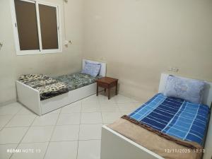 two beds sitting in a room with a window at App luxe riad zitoune in Meknès