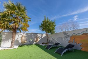 un muro con due palme e sedie sull'erba di La Villarina 