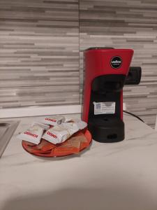 Una máquina de café roja encima de una cama. en Appartamento a MXP Aeroporto-Via Mameli, en Somma Lombardo