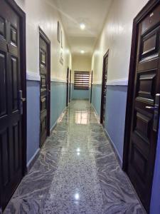 a hallway with doors and a tile floor at J-D Suites in Ozuoba