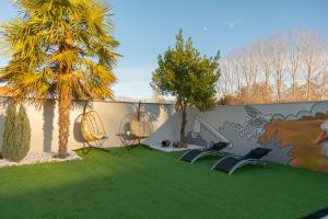 a garden with chairs and a fence with a palm tree at La Villarina in Sitrama de Tera