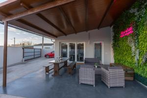 a patio with a table and chairs and a green wall at La Villarina in Sitrama de Tera +22 photos