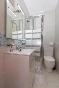 un bagno con lavandino, WC e specchio di La Villarina 