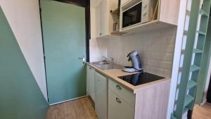 a small kitchen with a sink and a microwave at Studio Cosy - Proche Tram et Gare de Grenoble in Fontaine
