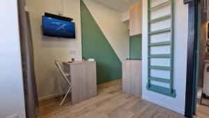 a room with a table and a tv on the wall at Studio Cosy - Proche Tram et Gare de Grenoble in Fontaine