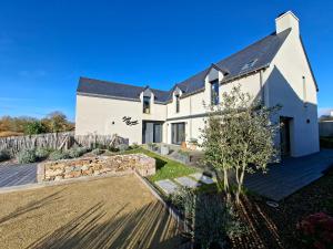 een wit huis met een hek en een tuin bij Chambre d'hôtes Seiz Breur in Lancieux