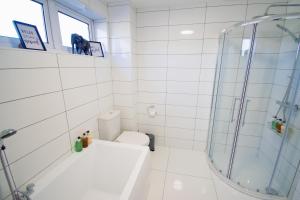 a white bathroom with a shower and a toilet at Ideal Home Away in Whitefield Bury in Manchester