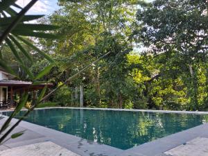 a swimming pool with trees in the background at Blue Lake Ridge in Maha Oya