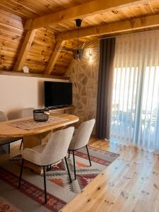 a living room with a wooden table and chairs at Guest House Sara 2 in Žabljak