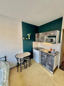 uma pequena cozinha com uma pia e uma mesa em Hyper Centre de Valence - Studio N22 em Valence
