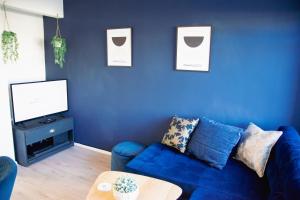 a blue living room with a blue couch and a tv at Ideal Home Away in Whitefield Bury in Manchester