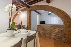 Zimmer mit Ziegelwand, Tisch und Stühlen in der Unterkunft La casetta dell'amore di Mimmi in Castel Viscardo