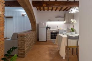 eine Küche mit einem Tisch und einem weißen Kühlschrank in der Unterkunft La casetta dell'amore di Mimmi in Castel Viscardo
