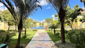 un camino a través de un parque con palmeras y edificios en The Sun Full Condominiun, en Brasilia